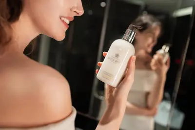 a woman holding a bottle of soap in front of a mirror at Opus Residences by Opus Hospitality in Kuala Lumpur