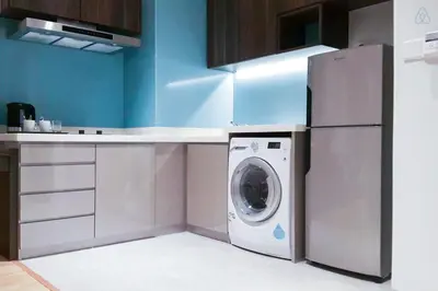 a kitchen with a washing machine and a refrigerator at D'Majestic by Plush in Kuala Lumpur