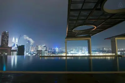 a view of a city skyline at night from a pool at D'Majestic by Plush in Kuala Lumpur