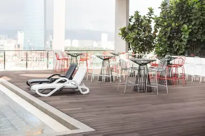 a swimming pool with chairs and tables on a balcony at D'Majestic by Plush in Kuala Lumpur