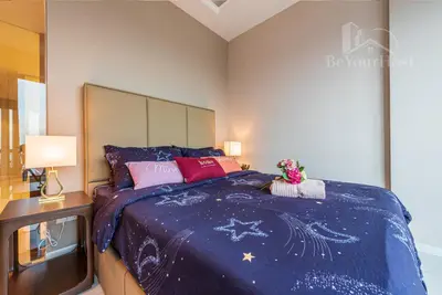 a bedroom with a bed with a blue comforter at Dorsett Residences Sri Hartamas in Kuala Lumpur