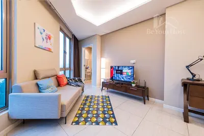 a living room with a couch and a tv at Dorsett Residences Sri Hartamas in Kuala Lumpur