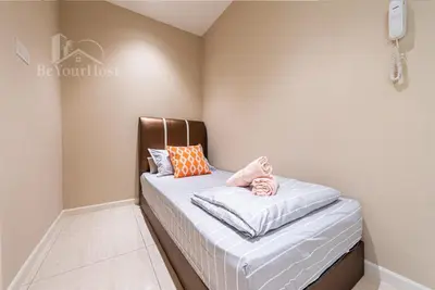 a small bedroom with a bed in the corner at Dorsett Residences Sri Hartamas in Kuala Lumpur