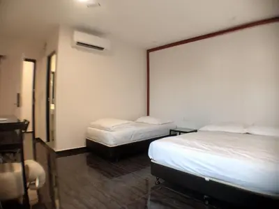 a hotel room with two beds and a desk at M Design Hotel @ Taman Pertama in Kuala Lumpur