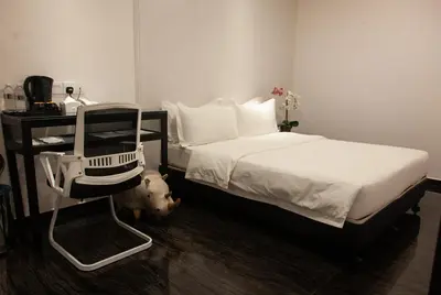 a hotel room with a bed and a chair at M Design Hotel @ Taman Pertama in Kuala Lumpur