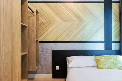 a bedroom with a bed with a blue headboard at Arte Plus Kuala Lumpur in Kuala Lumpur