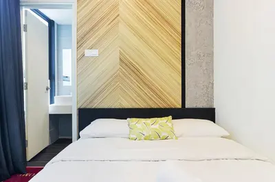 a bedroom with a bed with a wooden wall at Arte Plus Kuala Lumpur in Kuala Lumpur