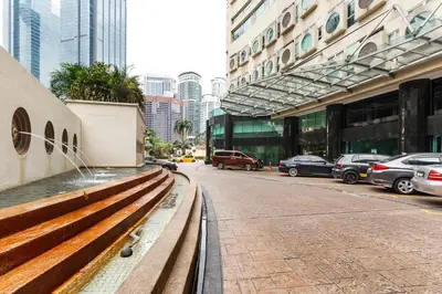 a bench on a city street with cars parked at Parkview Suites KLCC by Airhost in Kuala Lumpur