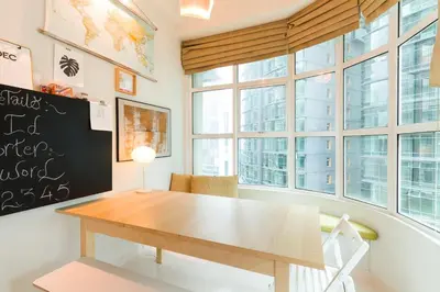 a table and chairs in a room with windows at Parkview Suites KLCC by Airhost in Kuala Lumpur