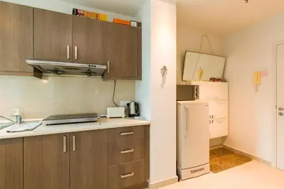 a kitchen with wooden cabinets and a refrigerator at Parkview Suites KLCC by Airhost in Kuala Lumpur