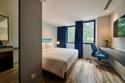 a hotel room with a bed and a desk and window at J-Hotel by Dorsett in Kuala Lumpur
