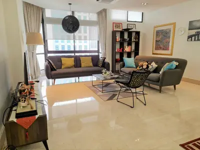 a living room with a couch and a table at Bukit Bintang Apartment by Sarah's Lodge @ Fahrenheit88 in Kuala Lumpur