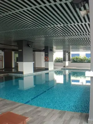 a large swimming pool with blue water in a building at VUE RESIDENCE SERVICE SUITE - Studio 3 pax in Kuala Lumpur