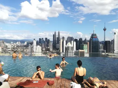 a group of people sitting in a pool with a city at Regalia suites & residence 2 bedroom apartment by Enjoy your stay in Kuala Lumpur
