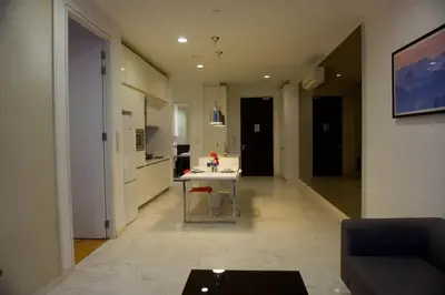 a living room with a table and a kitchen at La Platinum KLCC in Kuala Lumpur