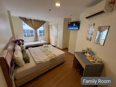 a bedroom with a large bed and a family room at SCC Hotel City Centre in Kuala Lumpur