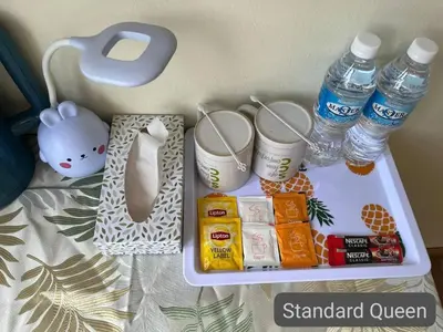 a tray with bottles of water and snacks on a bed at SCC Hotel City Centre in Kuala Lumpur