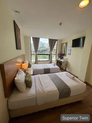 a hotel room with two beds and a window at SCC Hotel City Centre in Kuala Lumpur