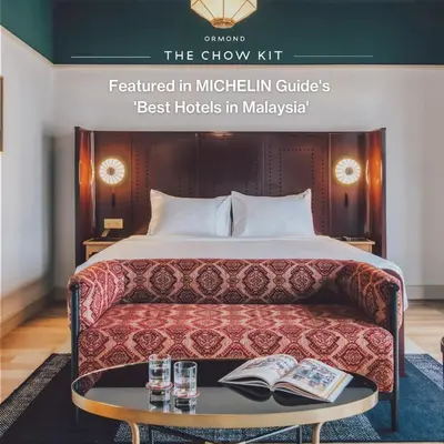 a hotel room with a bed and a table with books at The Chow Kit - an Ormond Hotel in Kuala Lumpur
