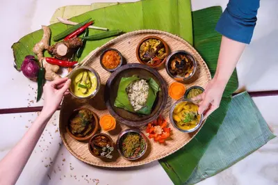 a plate of food on top of a banana leaf at The Chow Kit - an Ormond Hotel in Kuala Lumpur
