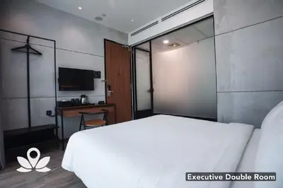a bedroom with a white bed and a desk at Ceria Hotel in Kuala Lumpur