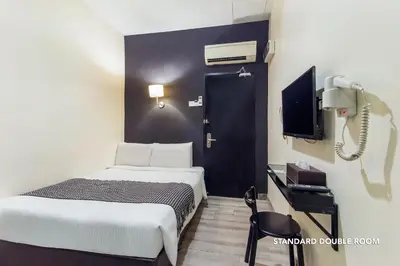 a hotel room with a bed and a phone at Ceria Hotel in Kuala Lumpur