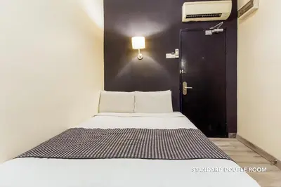 a bed in a room with a black door at Ceria Hotel in Kuala Lumpur