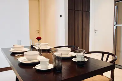 a wooden table with plates and bowls and glasses at Damai 88 by Moka near KLCC in Kuala Lumpur