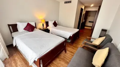 a hotel room with two beds and a couch at RJ Service Suite at Times Square in Kuala Lumpur