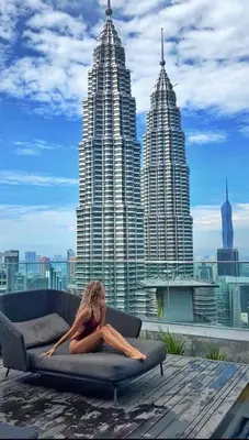 a woman laying on a couch in front of some tall buildings at Like Home Star KLCC in Kuala Lumpur