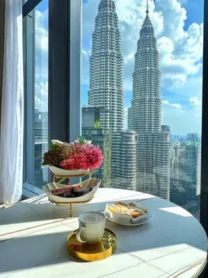 a table with two plates of food in front of a window at Like Home Star KLCC in Kuala Lumpur