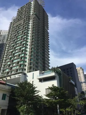 a tall building with trees in front of it at Deluxe Swiss Garden Residences Bukit Bintang City Center in Kuala Lumpur