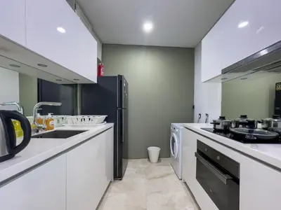 a kitchen with white counters and a sink and a dishwasher at Vortex Suites KLCC by BlackNest in Kuala Lumpur
