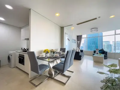 a dining room and living room with a table and chairs at Vortex Suites KLCC by BlackNest in Kuala Lumpur