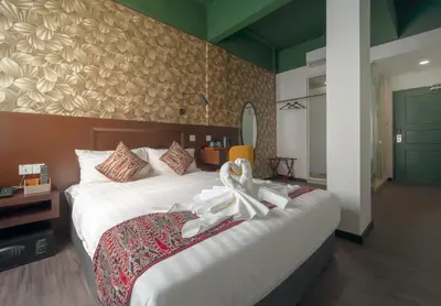 a bedroom with a large bed with white towels on it at East Riverine Boutique Hotel in Kuala Lumpur
