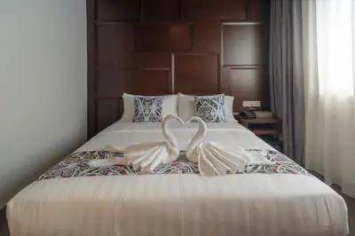 a bed with two swans made to look like hearts at East Riverine Boutique Hotel in Kuala Lumpur