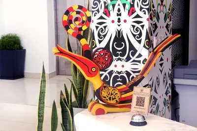 a colorful sculpture sitting on a table next to a plant at East Riverine Boutique Hotel in Kuala Lumpur