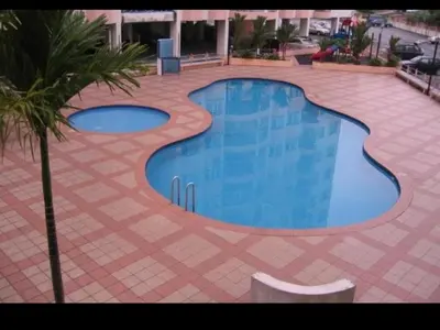 a large swimming pool in a tile yard with a palm tree at UMMII Homestay in Ampang