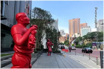 a red statue of people on a city street at TriBeCa 2bedroom 3min walk to bukit bintang 2 rooftop pool in Kuala Lumpur