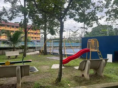a park with a playground with a slide and a tree at Mahasa Homestay Kuala Lumpur in Kuala Lumpur