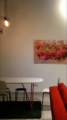 a dining room with a table and a painting on the wall at 3 Towers 10min to KLCC next to Hospital Gleneagle in Kuala Lumpur