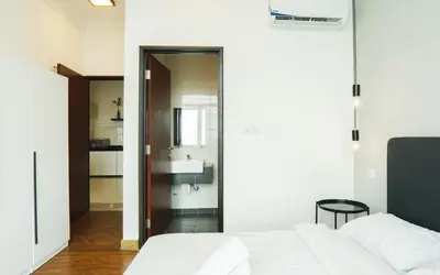 a bedroom with a white bed and a bathroom at Boulevard Service Apartment KL by Airhost in Kuala Lumpur