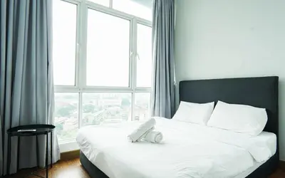 a bed with a phone on it in front of a window at Boulevard Service Apartment KL by Airhost in Kuala Lumpur
