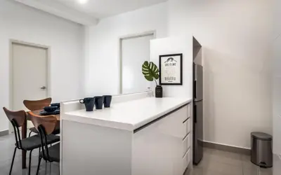 a kitchen with white cabinets and a black refrigerator at Arte Plus Jalan Ampang by Airhost in Kuala Lumpur
