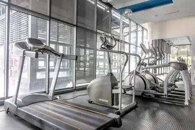 a gym with two treadmill machines in a room with windows at Rex Ollie @ The Elements Ampang in Kuala Lumpur