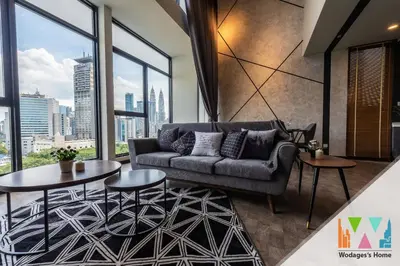 a living room with a couch and tables and windows at KLCC Expressionz by WGS in Kuala Lumpur