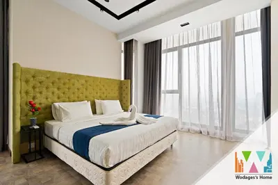 a bedroom with a large bed with a yellow headboard at KLCC Expressionz by WGS in Kuala Lumpur