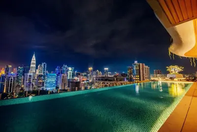 a swimming pool with a city skyline at night at Ceylonz Suites by MyKey in Kuala Lumpur