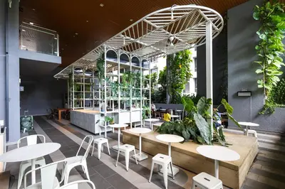 a restaurant with tables and chairs and plants at Ceylonz Suites by MyKey in Kuala Lumpur