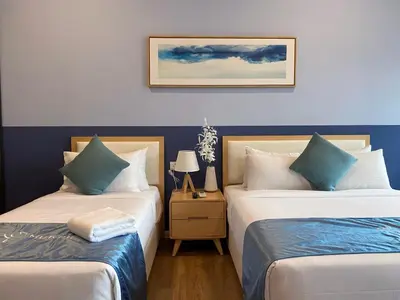 two beds in a room with blue and white at Ceylonz Suites by MyKey in Kuala Lumpur